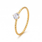 Gold faceted solitaire ring with a clear crystal on white