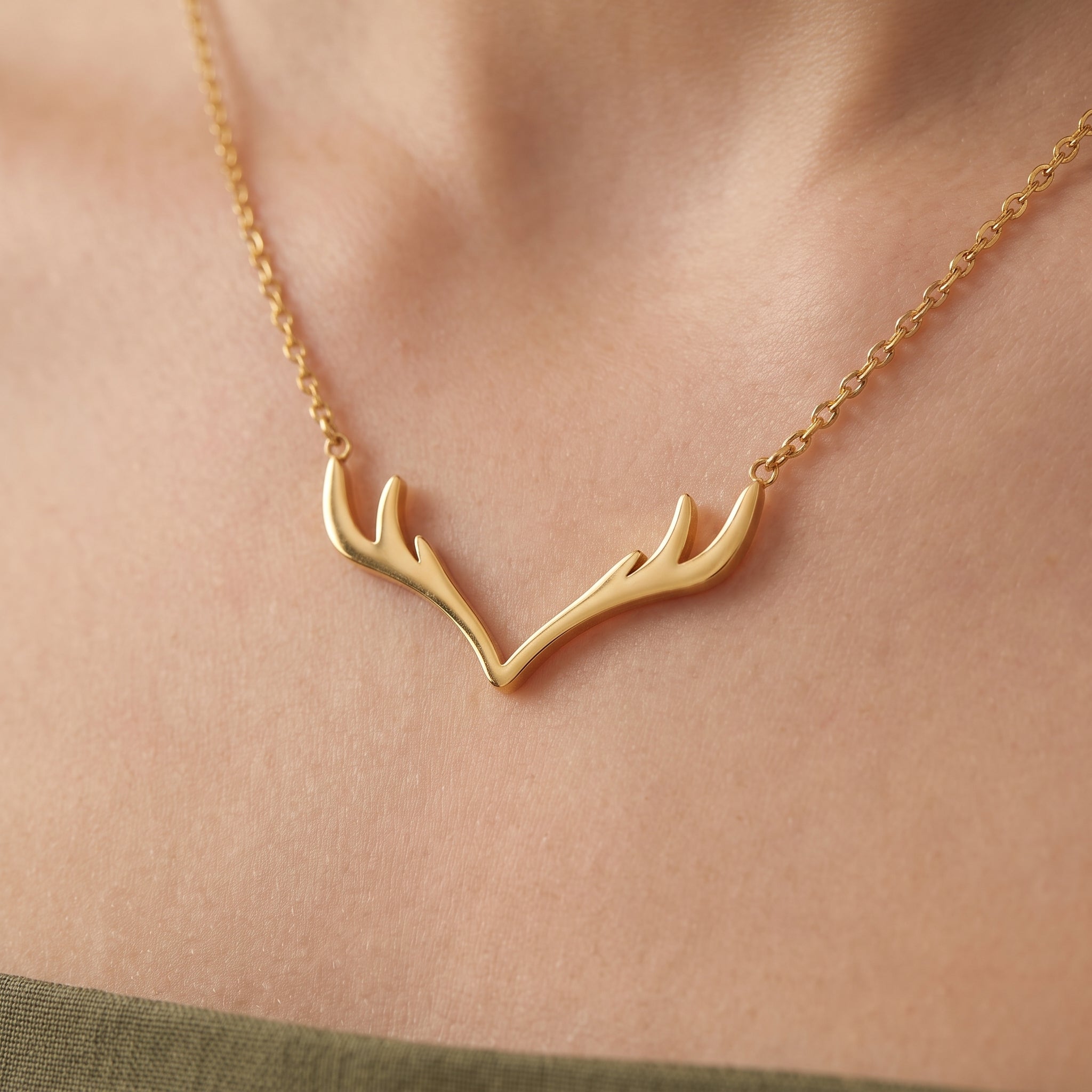 Gold antler pendant necklace, close-up of the pendant on the skin