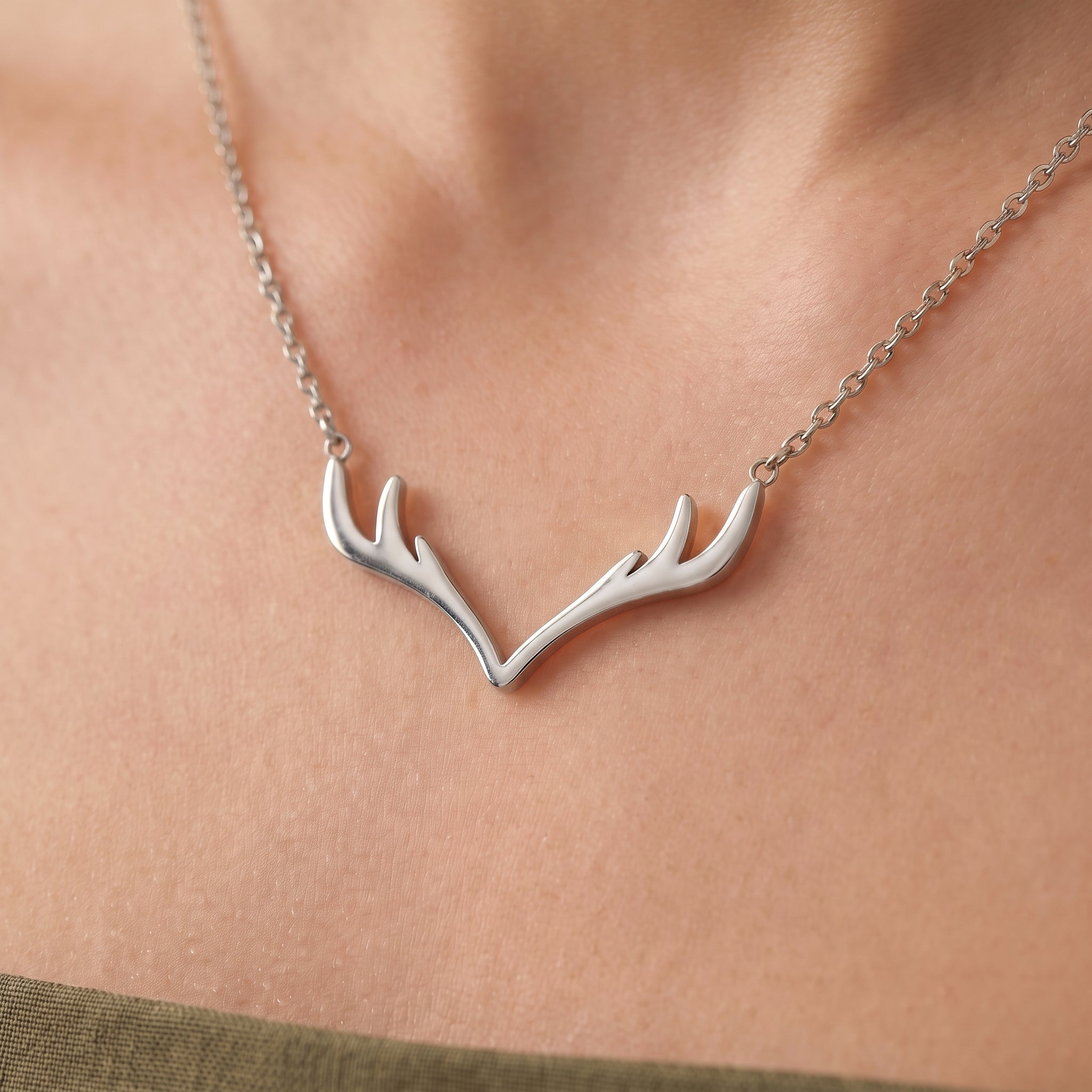 Silver antler pendant necklace, close-up of the pendant on the skin