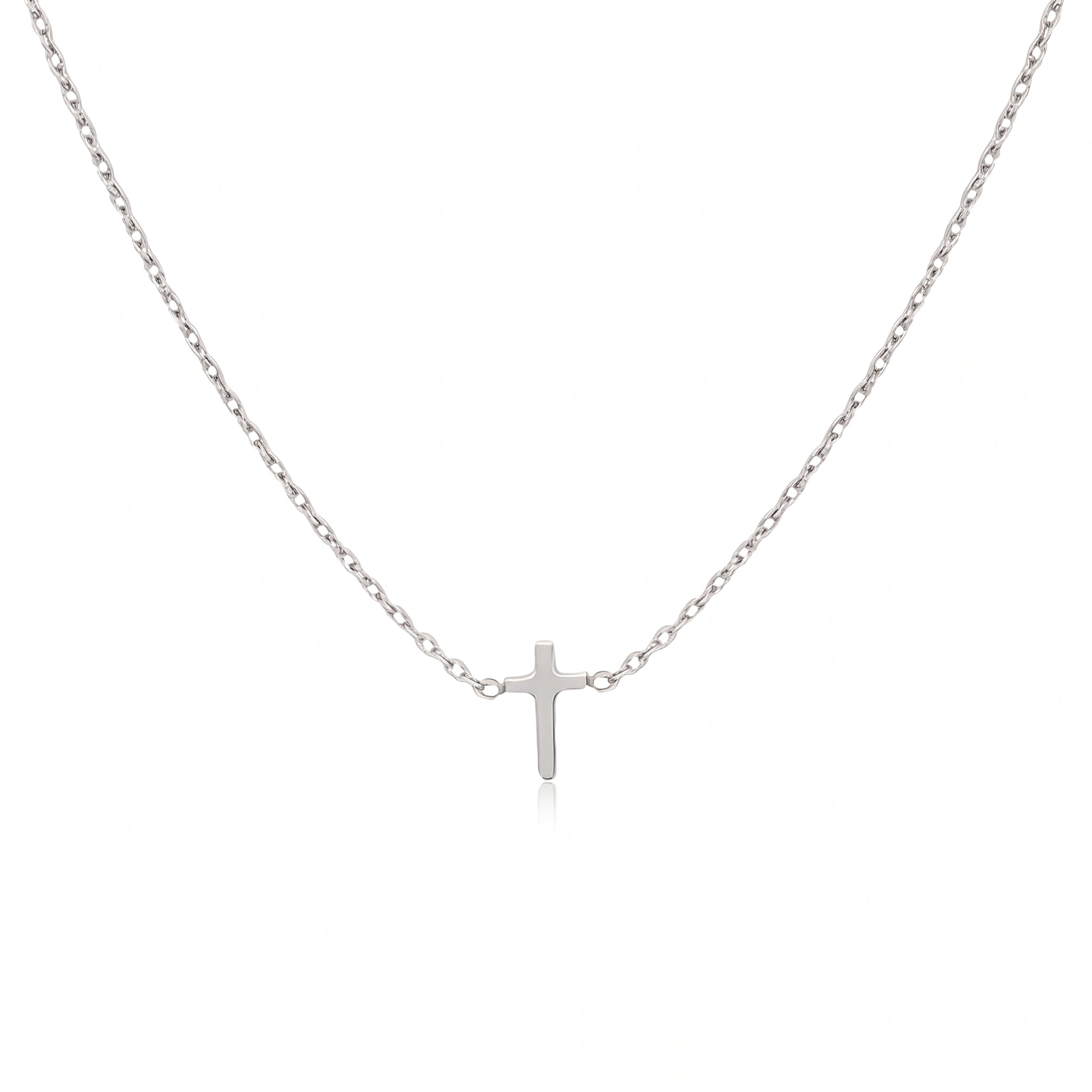 Silver tiny cross necklace laid out on a white background