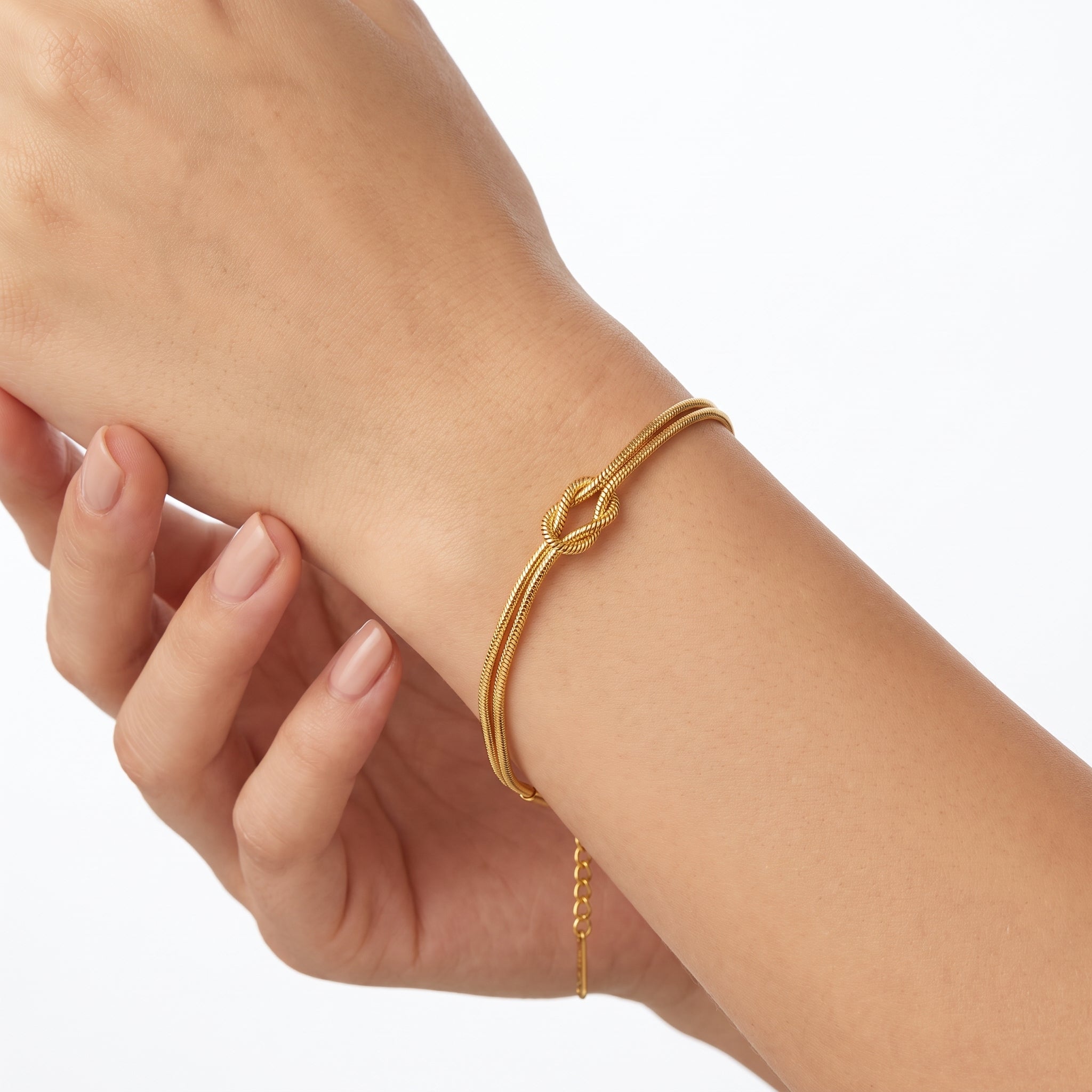 Gold love knot bracelet with double snake chain on the wrist