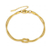 Gold love knot bracelet laid flat with clasp and extender