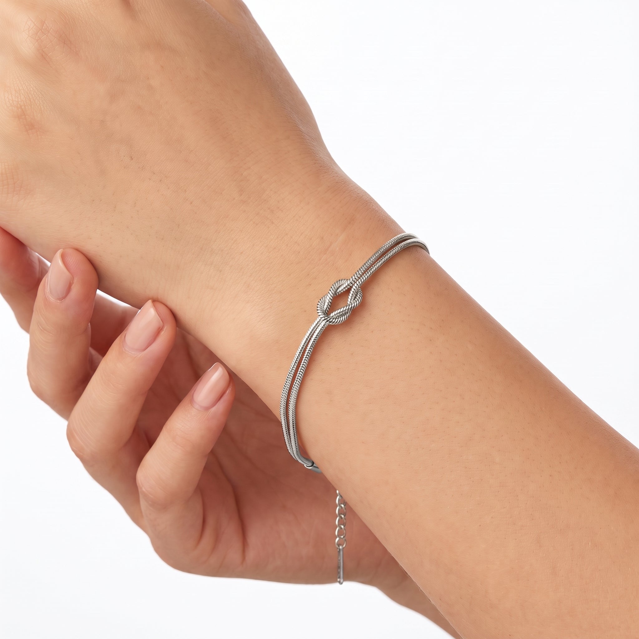 Silver love knot bracelet with double snake chain on the wrist