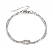 Silver love knot bracelet laid flat with clasp and extender