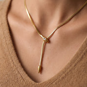 Gold snake necklace with a crystal snake head and lariat drop on skin