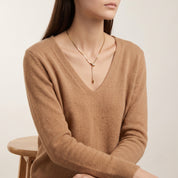 Vesper gold snake lariat necklace, seated portrait in a camel sweater