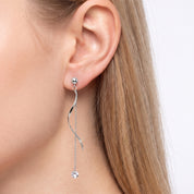 Silver wave drop earrings with a crystal chain worn on the ear
